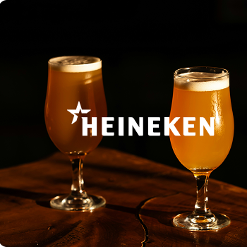 Zwei Biergläser mit Schaum auf einem dunklen Untergrund vor schwarzem Hintergrund