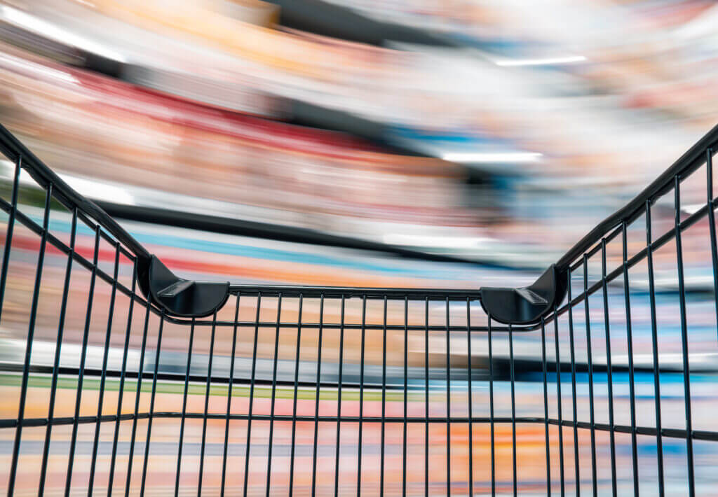 Blick aus einem Einkaufswagen auf verschwommene Regale in einem Gesch&auml;ft