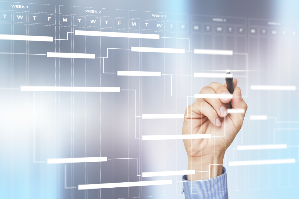 Hand in Hemd&auml;rmel h&auml;lt Stift vor transparentem Bildschirm mit Gantt-Diagramm und Wochen&uuml;bersicht