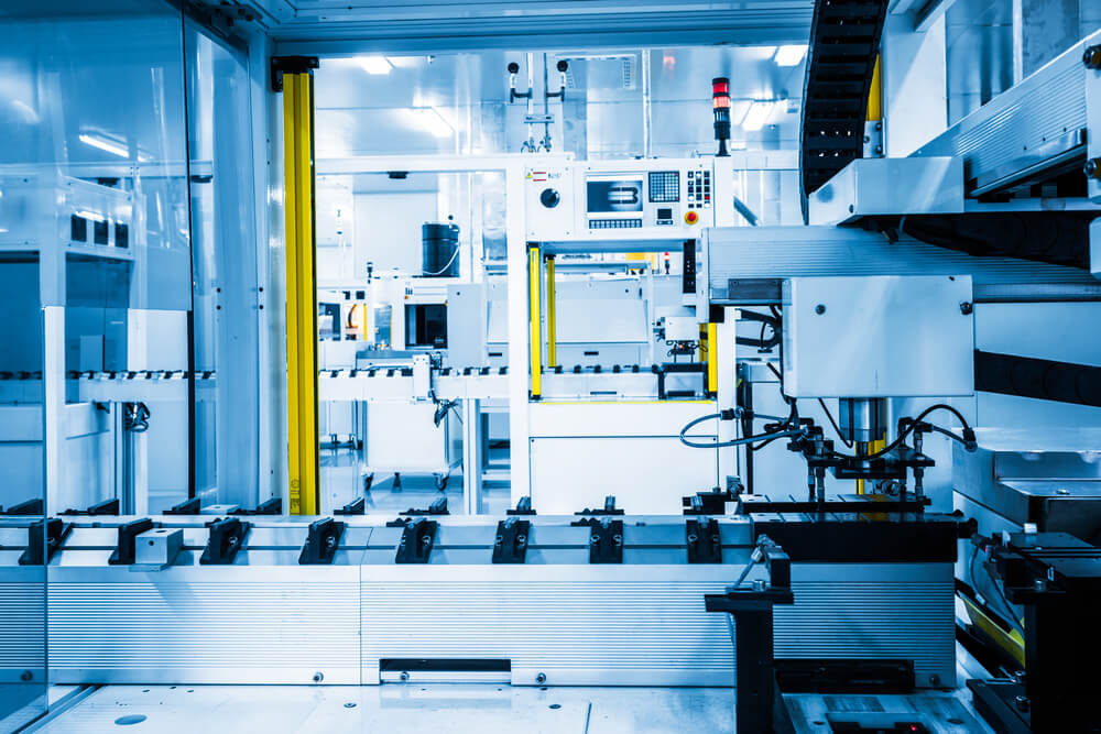 Industrielle Fertigungsanlage mit F&ouml;rderband und automatisierten Maschinen in einem Produktionsraum